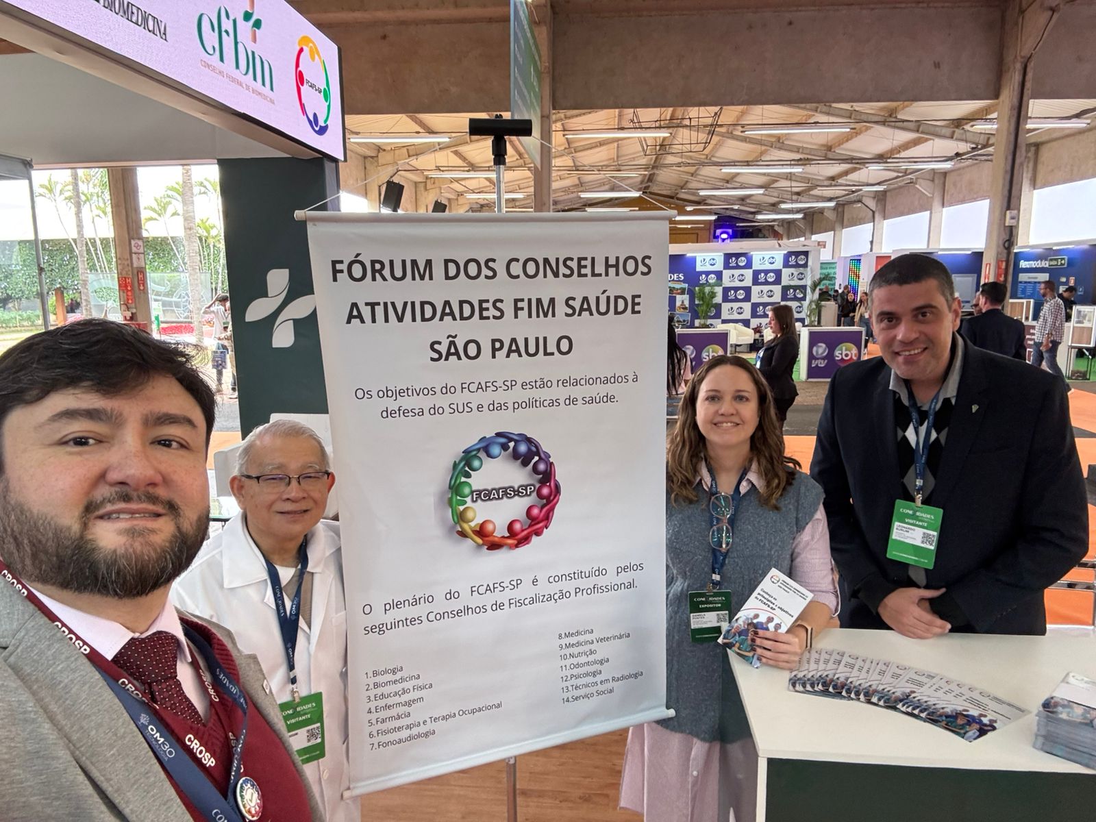 Três homens e uma mulher posando para foto com a placa do Fcafs.