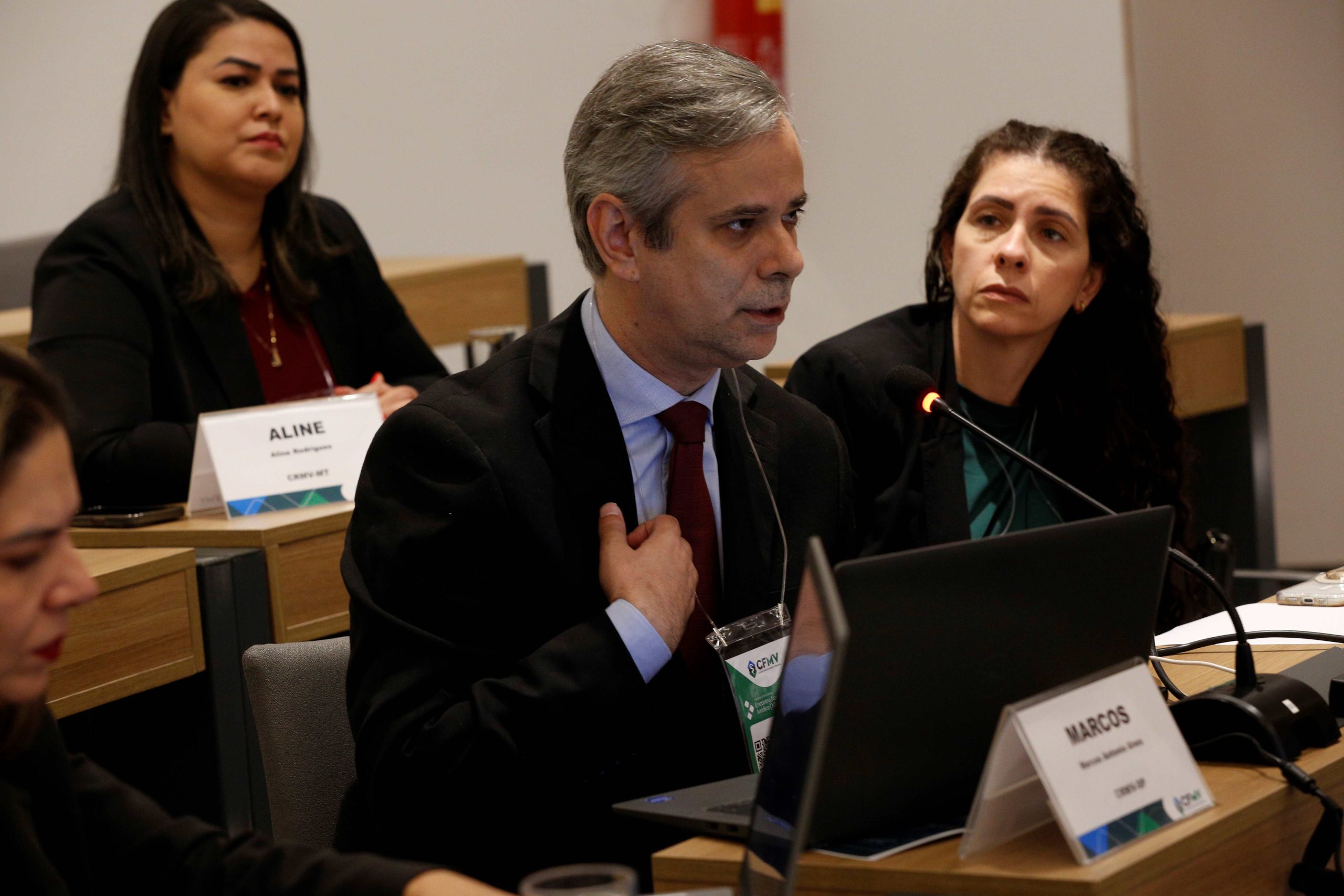 Homem falando ao microfone ao lado de mulher. São eles, o coordenador jurídico do CRMV-SP, Marcos Antônio Alves e a vice-presidente, Carolina Filippos.
