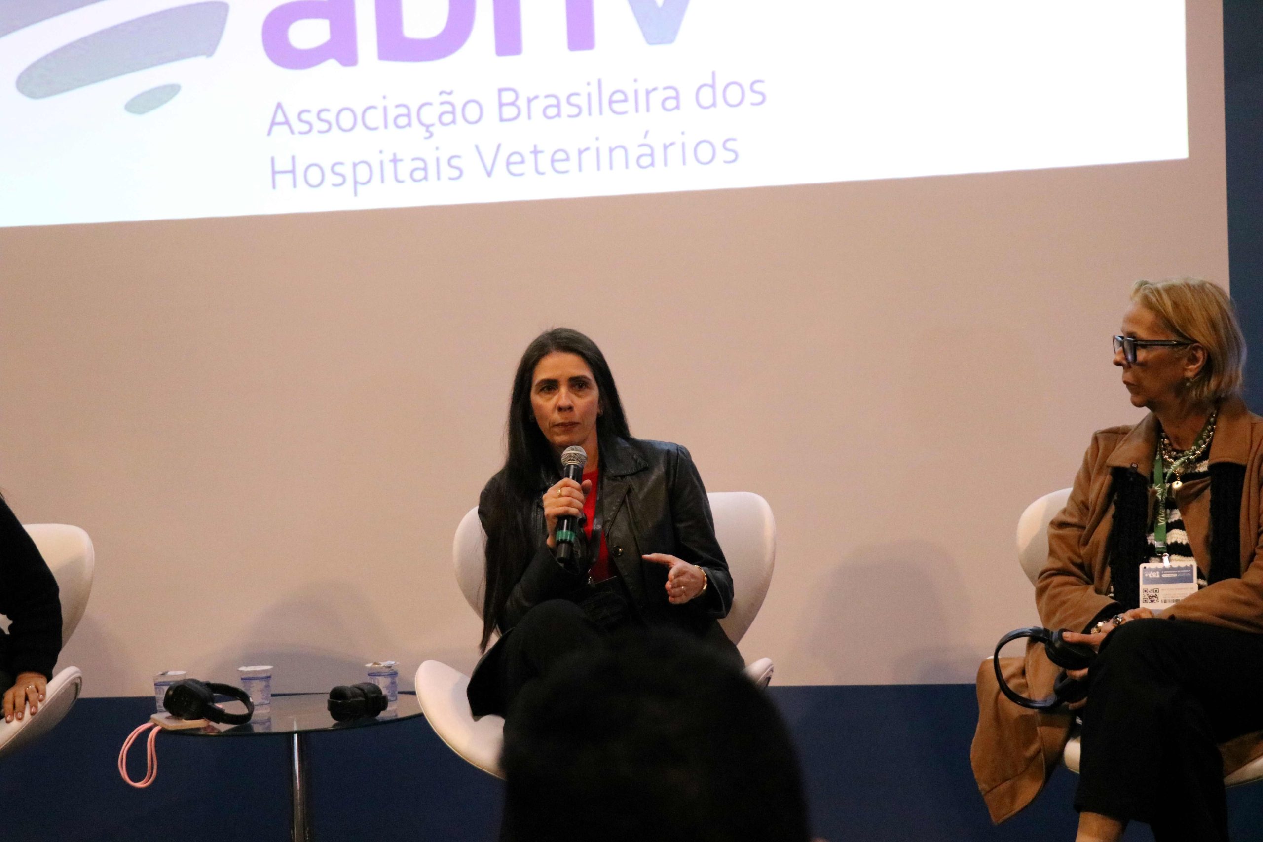 Mulher falando ao microfone frente ao telão. É a vice-presidente do CRMV-SP, Carolina Filippos.