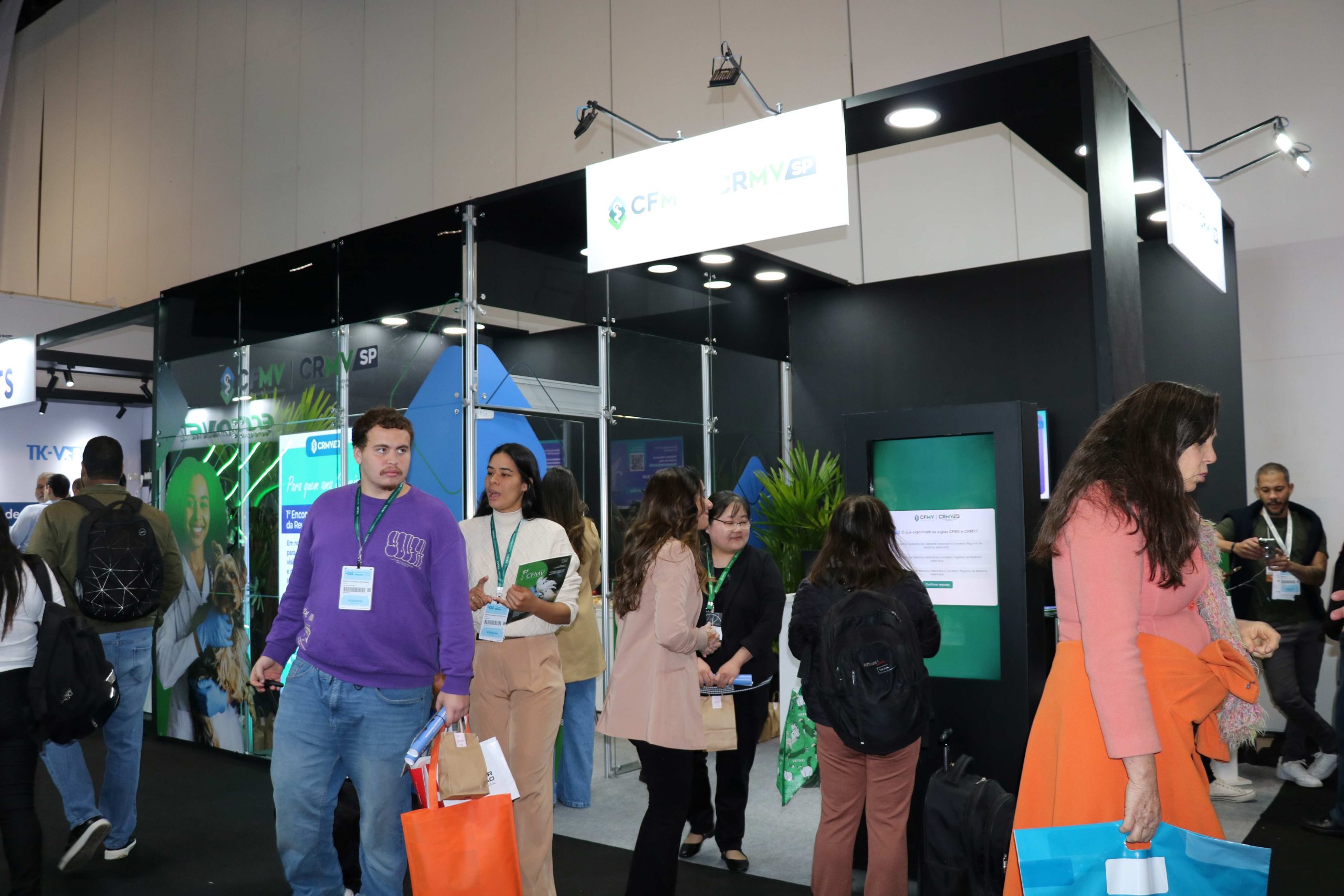 Pessoas reunidas frente a porta do evento.