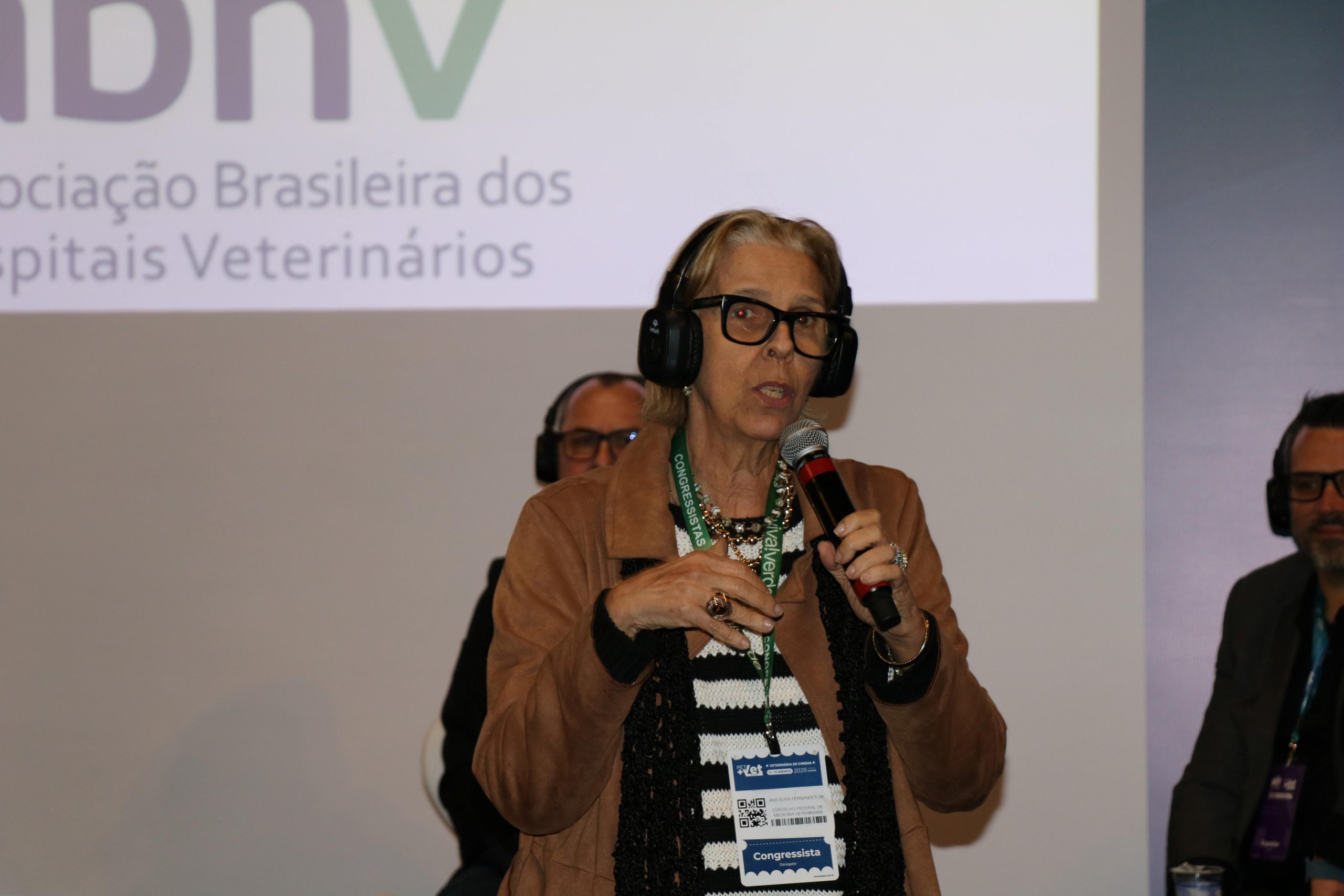 Mulher com fone de ouvido falando ao microfone. É a presidente do CFMV, Ana Elisa de Almeida.