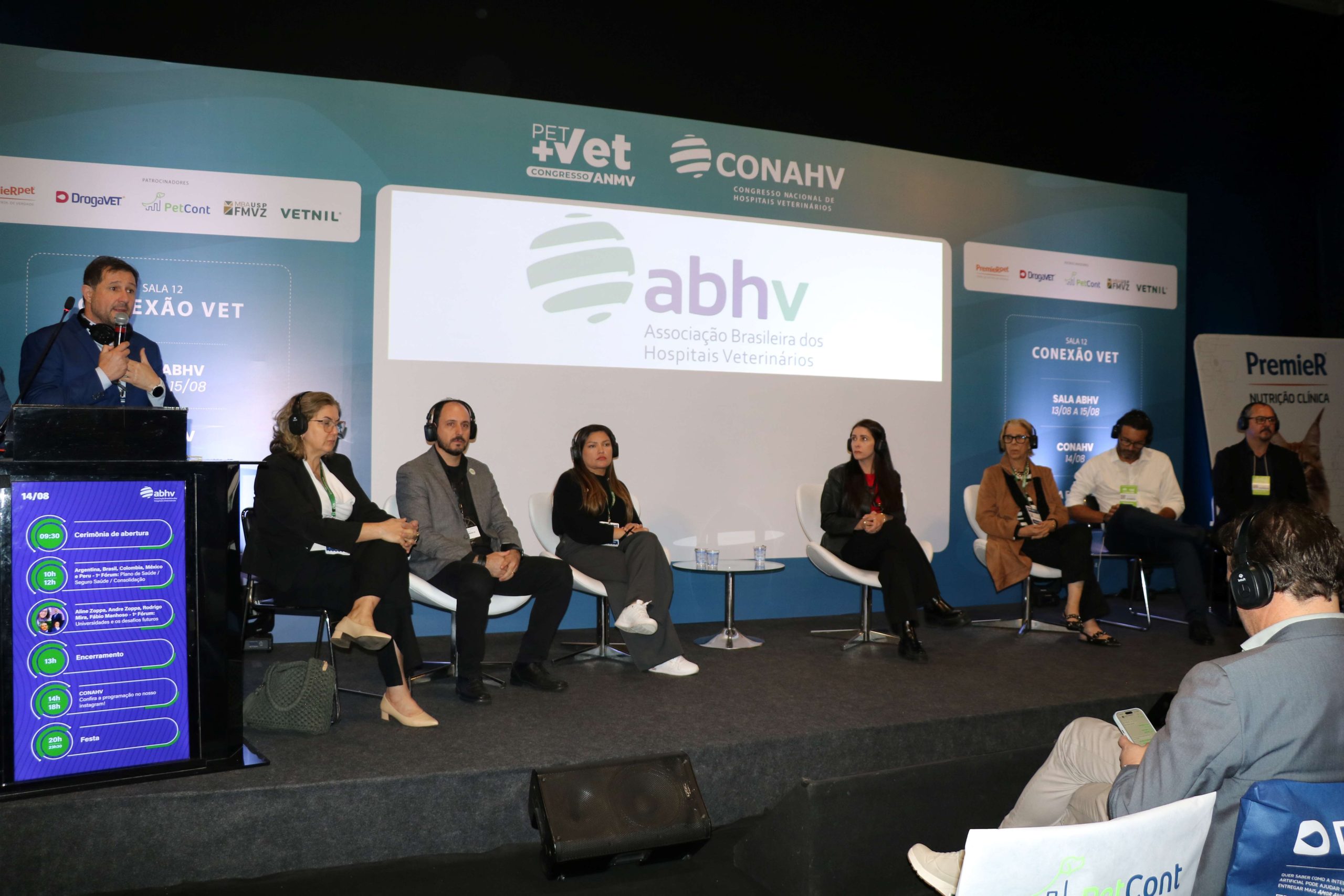 Pessoas sentadas em cadeiras frente ao telão durante debate da ABHV na PetVet.