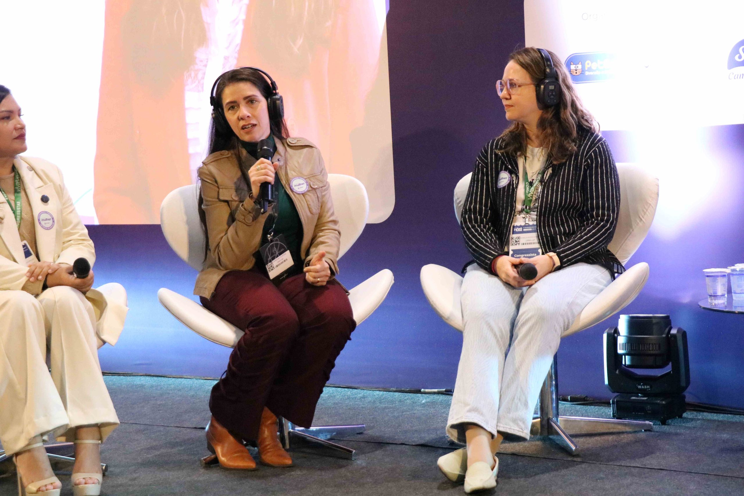 Três mulheres sentadas durante lançamento do Programa CFMV Mulher. Em destaque na imagem, da esquerda para a direita: a vice-presidente do CRMV-SP, Carolina Filippos e a presidente Daniela Pontes Chiebao.