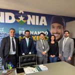 Pessoas reunidas para fotografia frente a mesa.