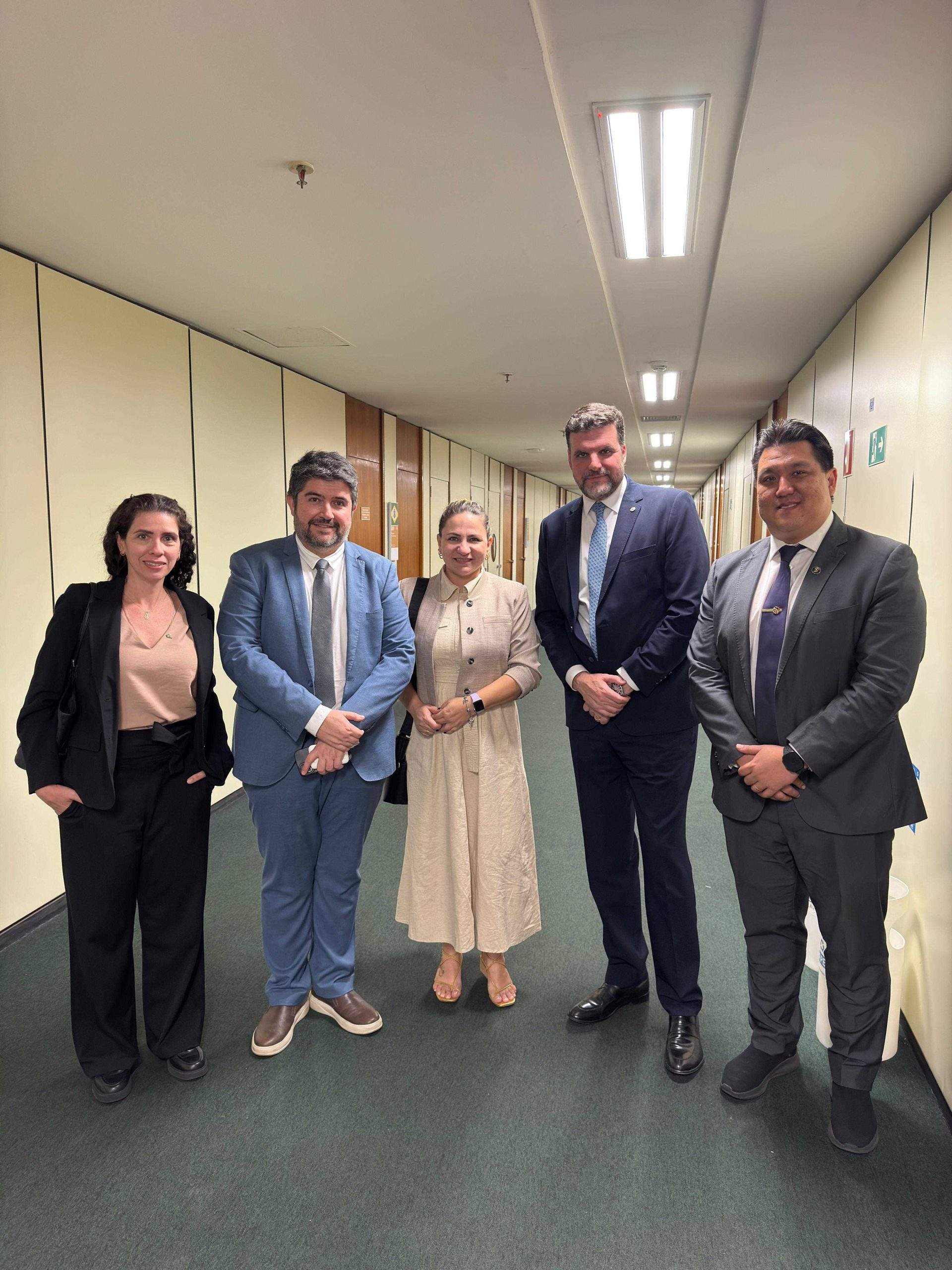 Cinco pessoas, três homens e duas mulheres, reunidas para fotografia.