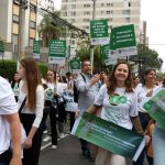 Na imagem é possível ver, da esquerda para a direita, a conselheira Alessandra Gonzales, a presidente do CRMV-SP Daniela Pontes Chiebao e ao lado direito dela, a vice-presidente Carolina Filippos, segurando faixas na cor verde com frases em letras brancas em defesa do ensino presencial.