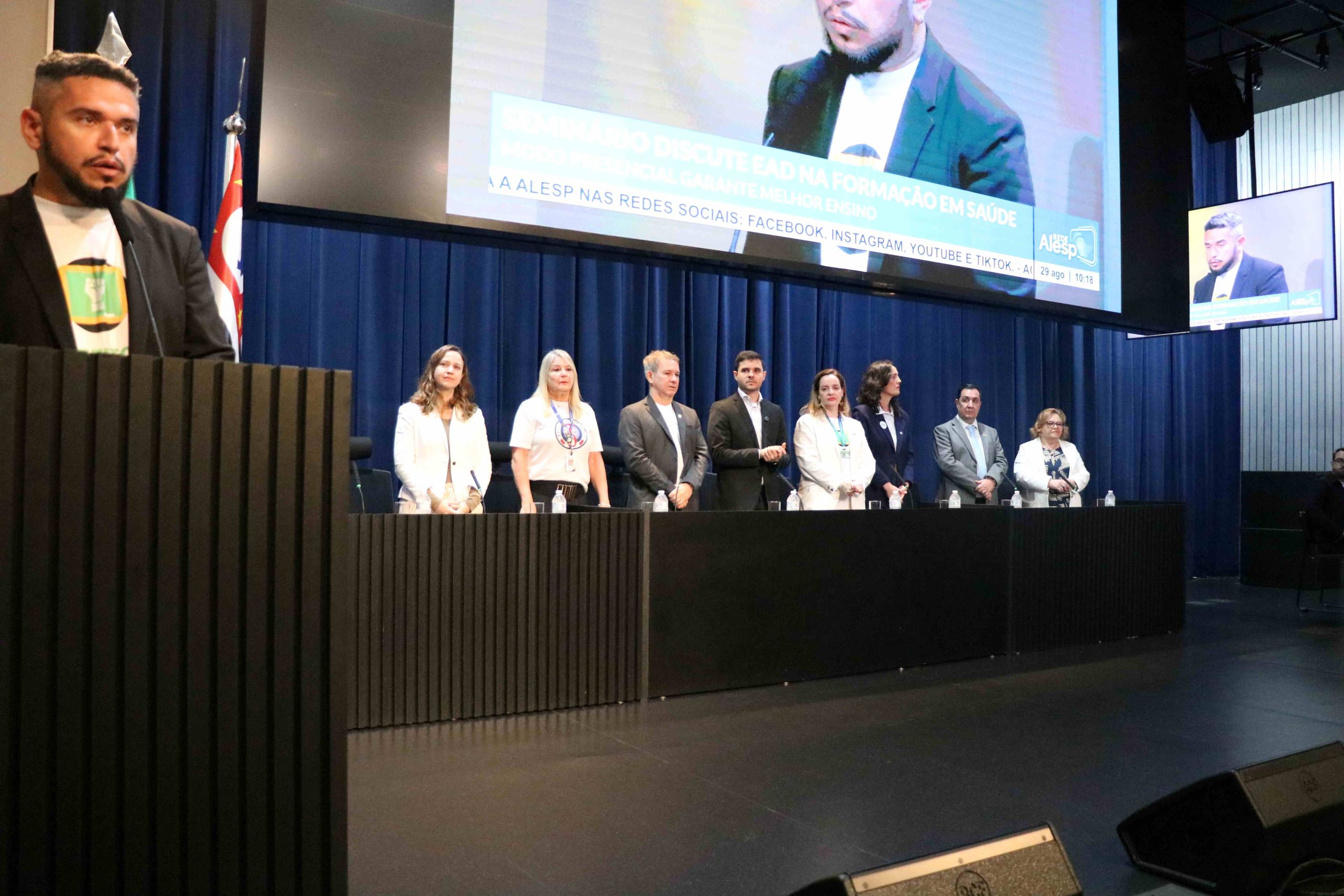 Pessoas em pé no palco preto pousando para foto.