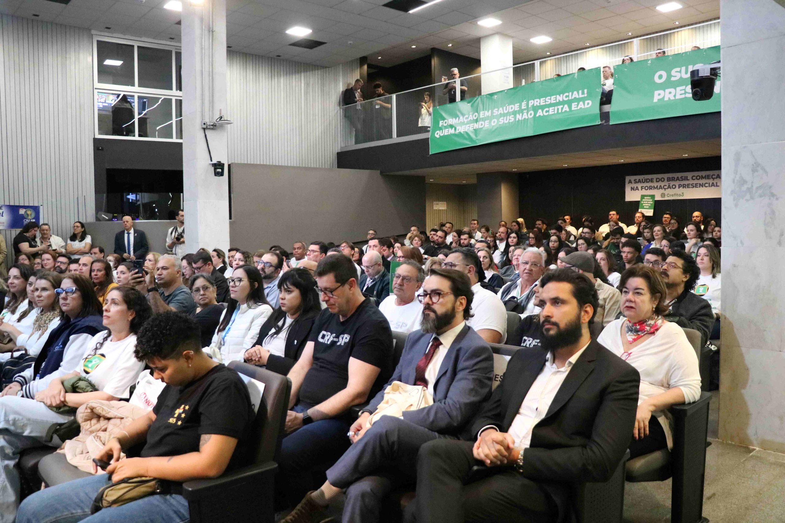 Pessoas sentada em um auditório.
