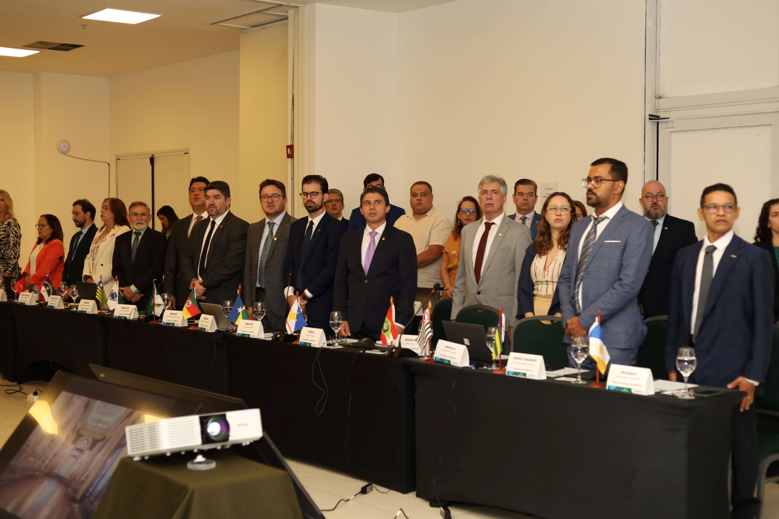Pessoas de pé frente a mesa reunidas.