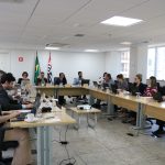 Imagem geral da sessão plenária de 10 de setembro mostrando conselheiros, diretoria e funcionários sentados em volta de uma mesa retangular.