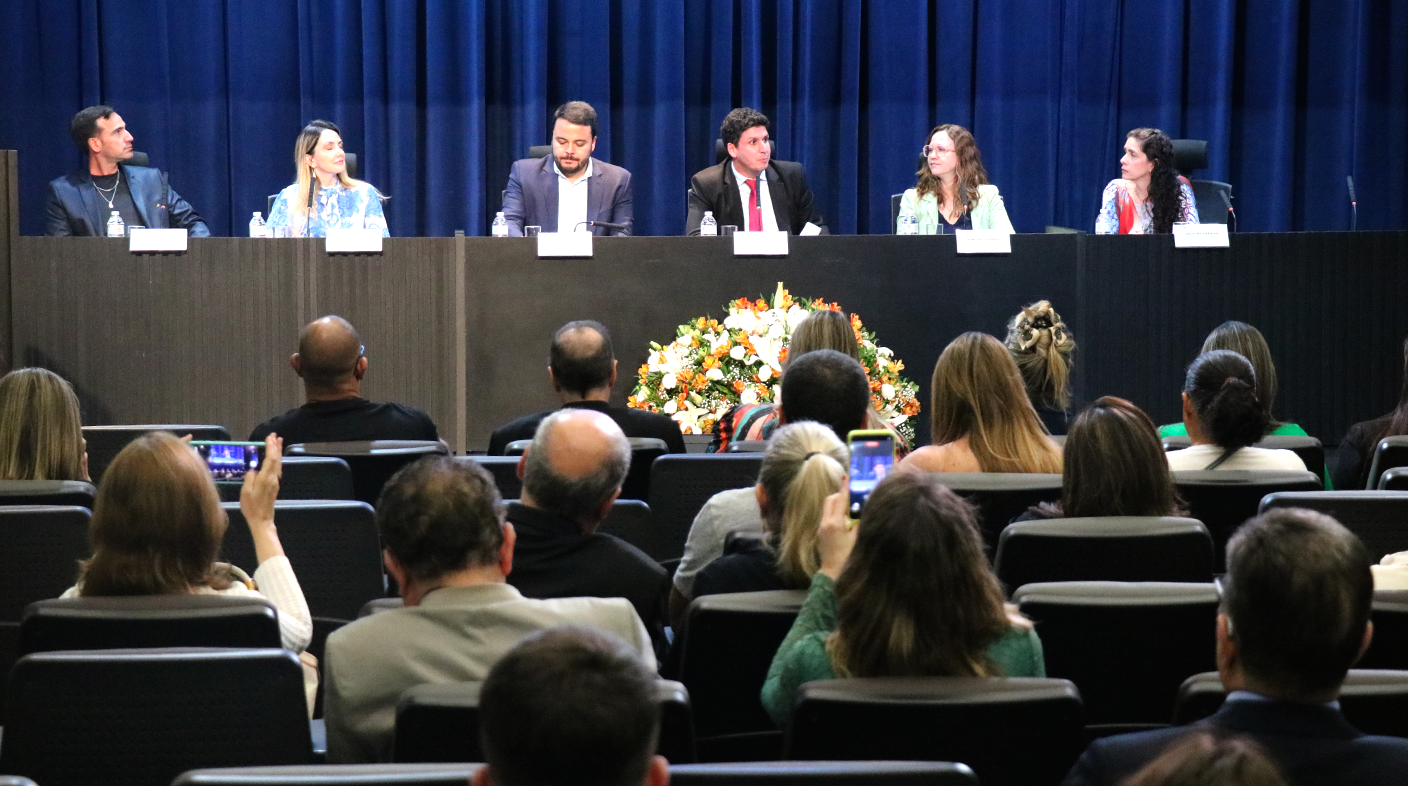 No auditório da Alesp, três homens e três mulheres sentados à mesa, no palco, em frente à plateia de médicos-veterinários.