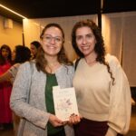 Presidente e vice-presidente do CRMV-SP posando para foto com livro.