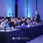 Pessoas sentadas em bancadas.