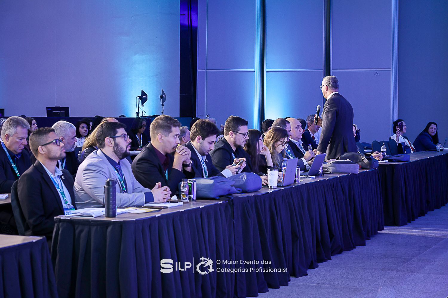 Pessoas sentadas em bancadas.