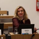 Mulher sentada frente a computador.