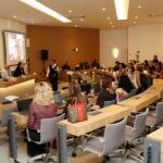 Pessoas sentadas frente ao público.