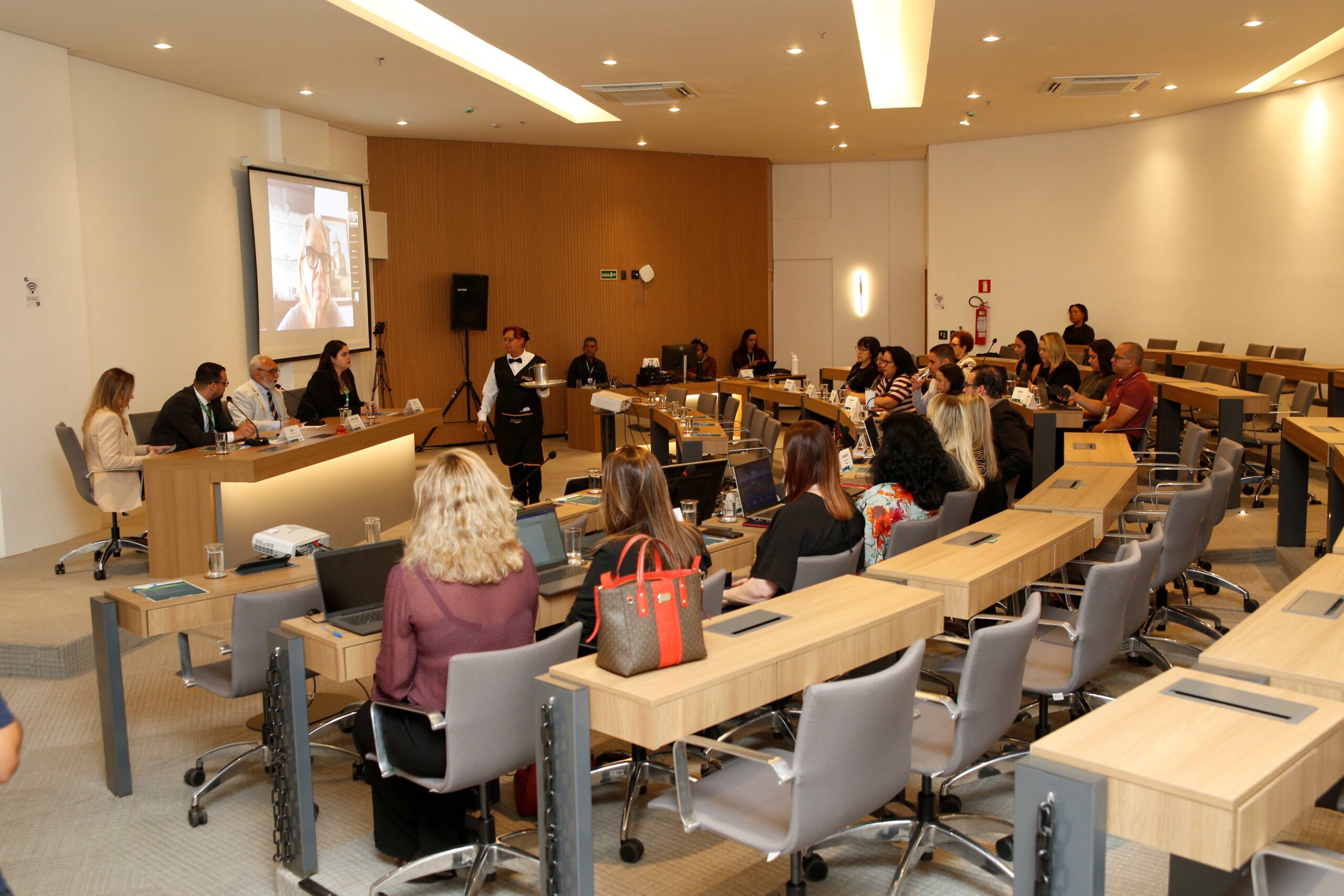 Pessoas sentadas frente ao público.