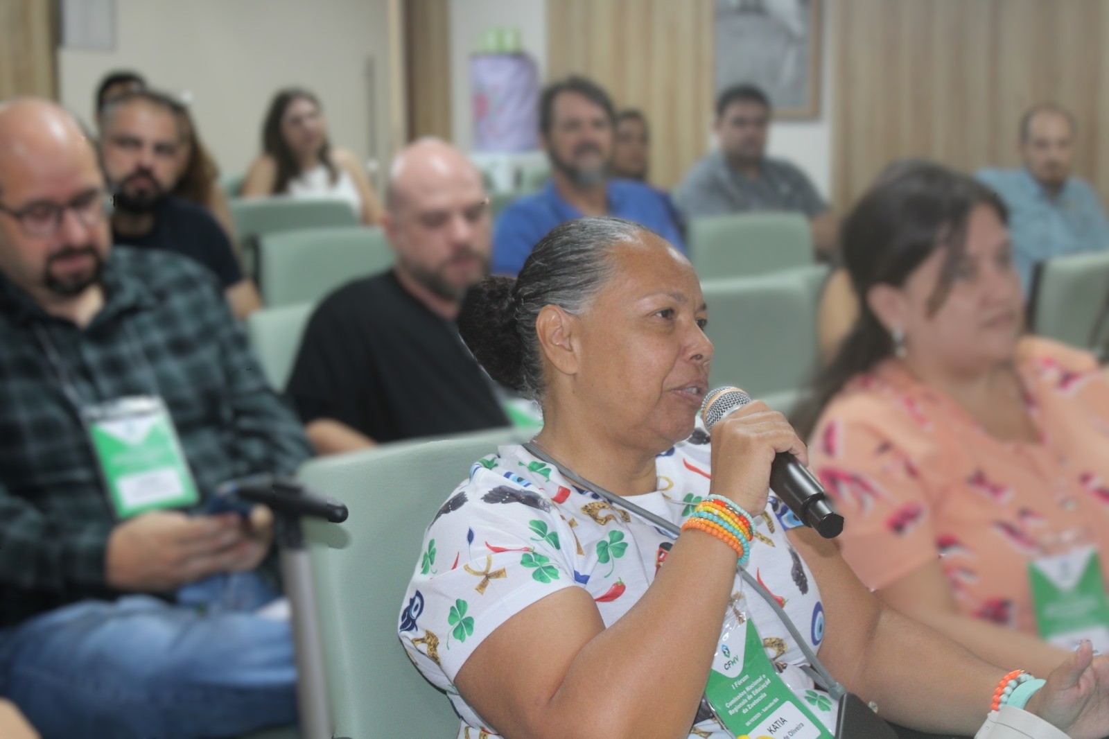 Mulher sentada falando no microfone.