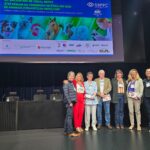 Pessoas reunidas posando para a foto no palco.