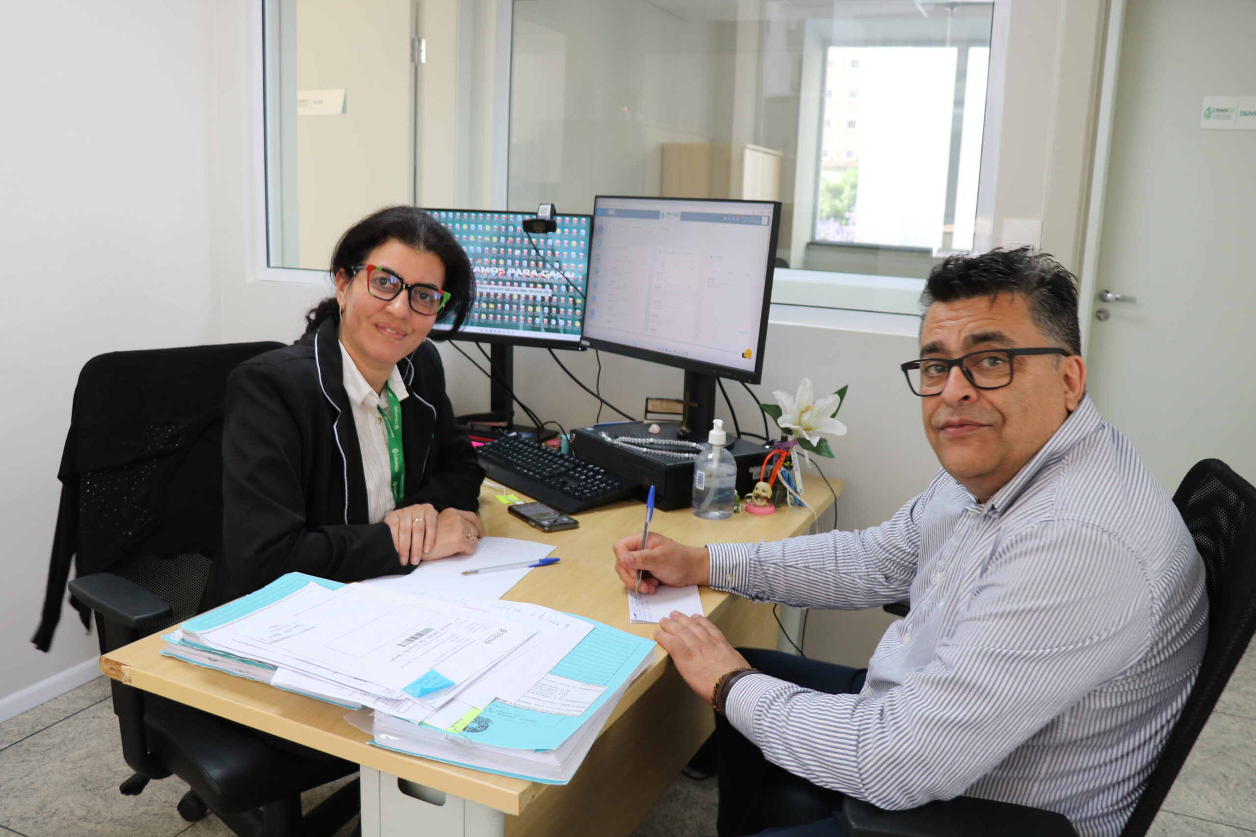 imagem de duas pessoas reunidas, trabalhando