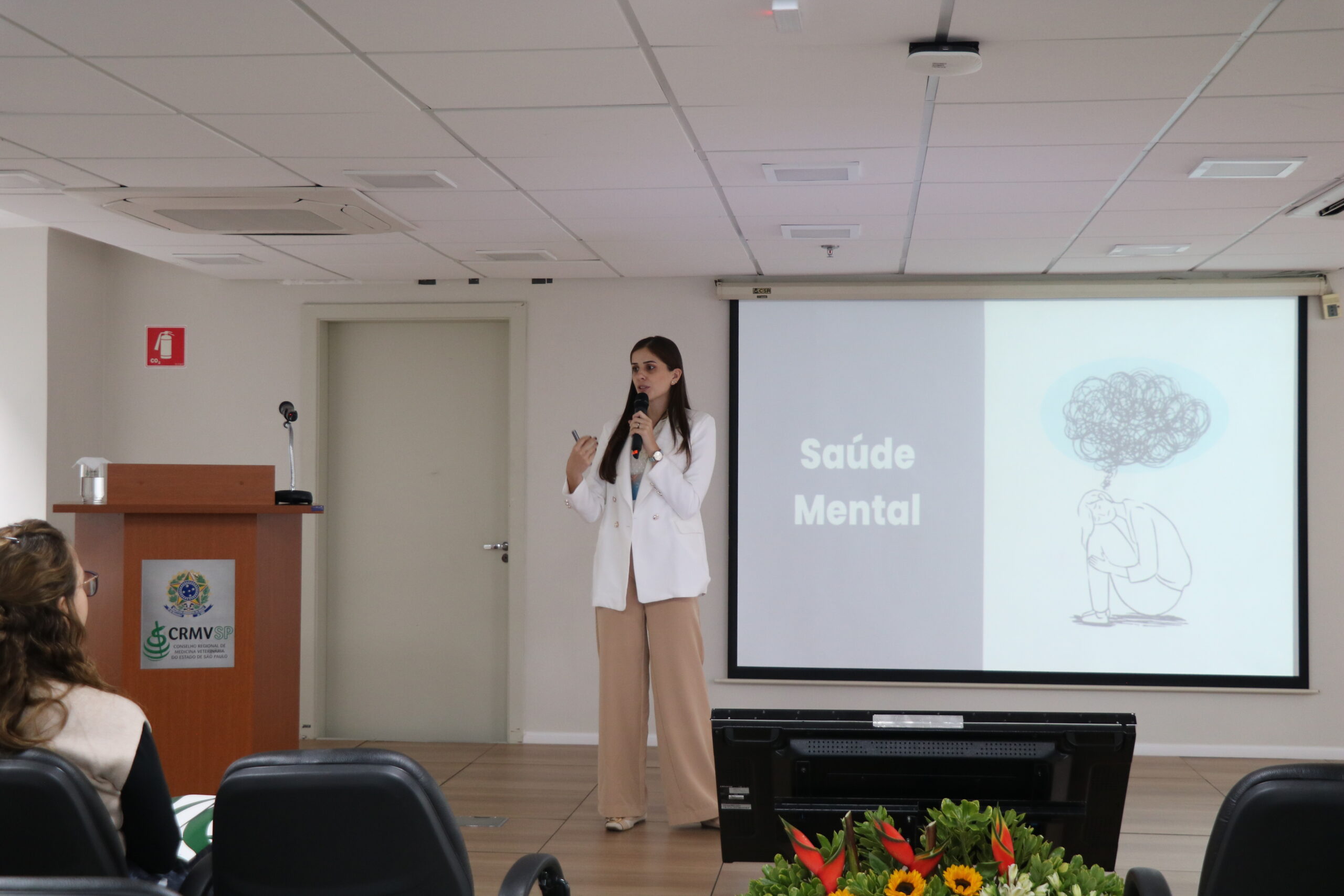 uma mulher palestrando sobre saude mental