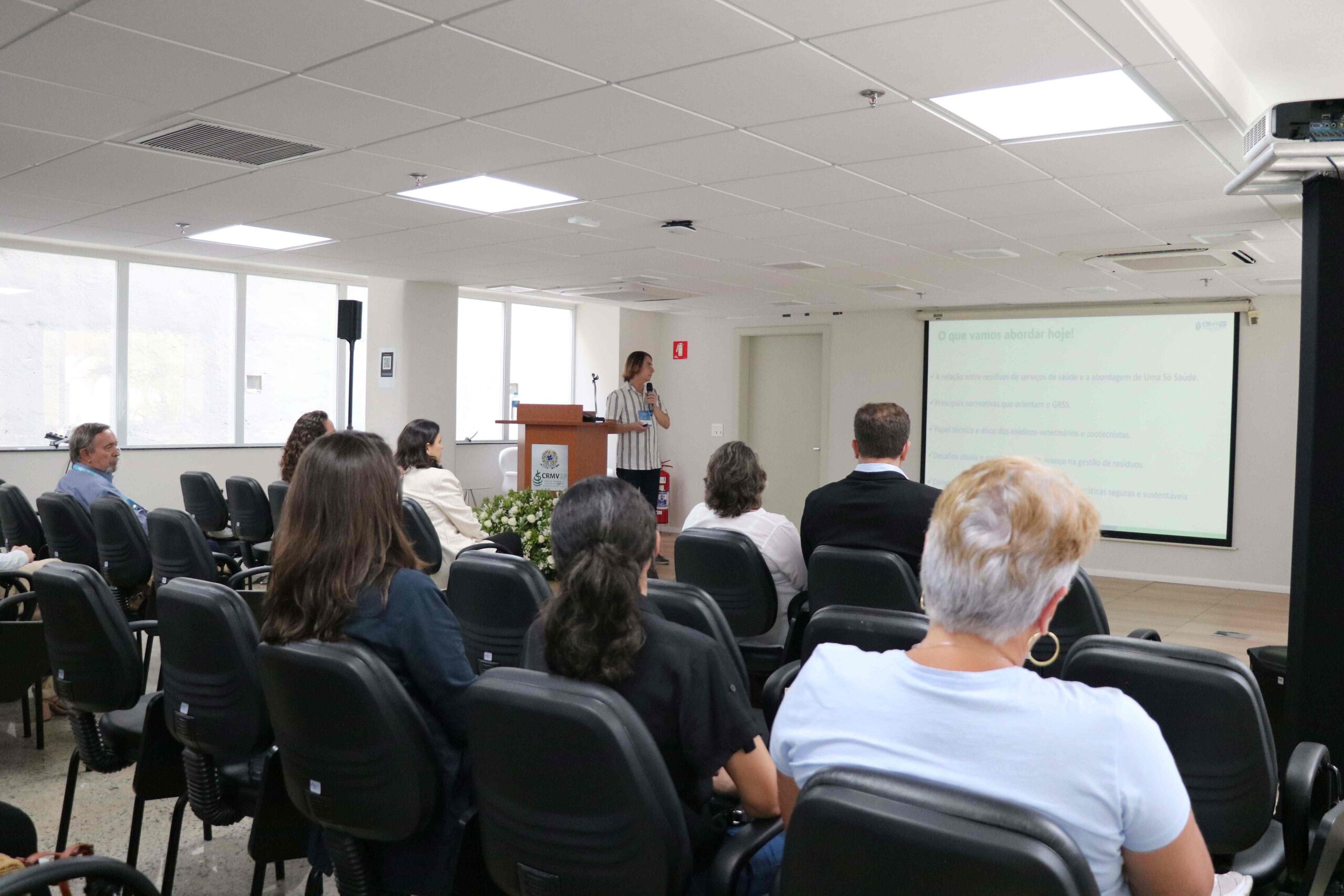 homem falando ao microfone frente ao público.