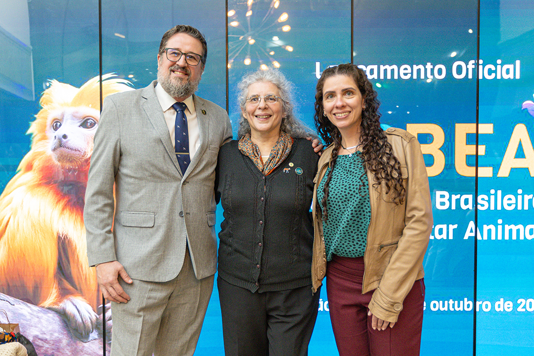 imagem de um homem e duas mulheres posados para foto