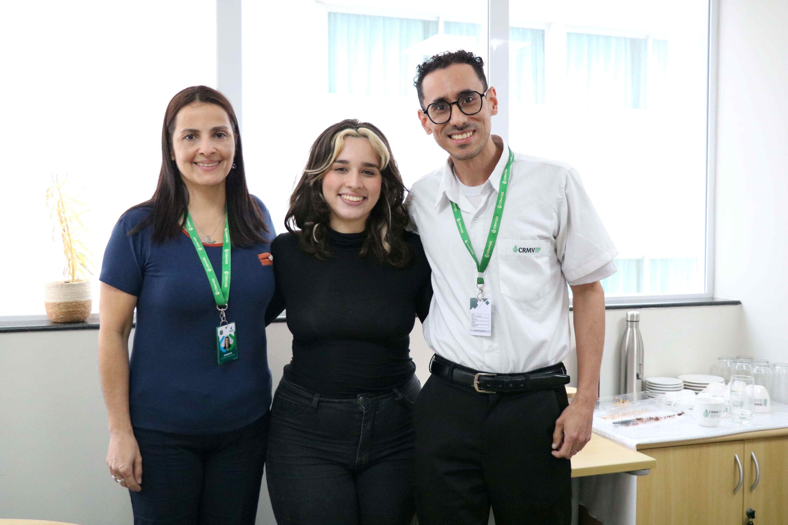 2 mulheres e 1 homem reunidos para fotografia.