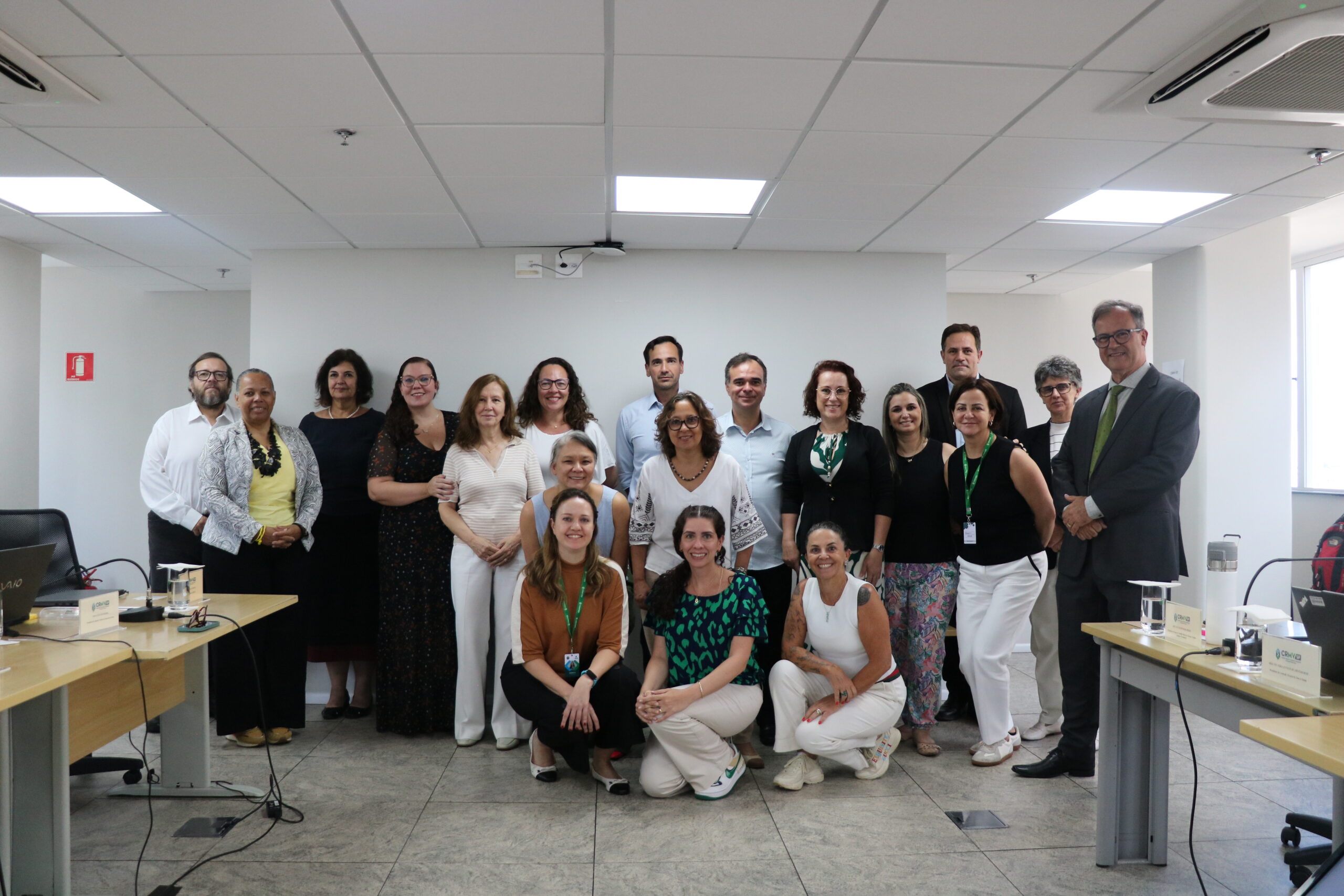 Homens e mulheres reunidos para a foto após a reunião.