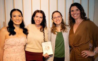 imagem de quatro mulheres, uma segurando um livro.