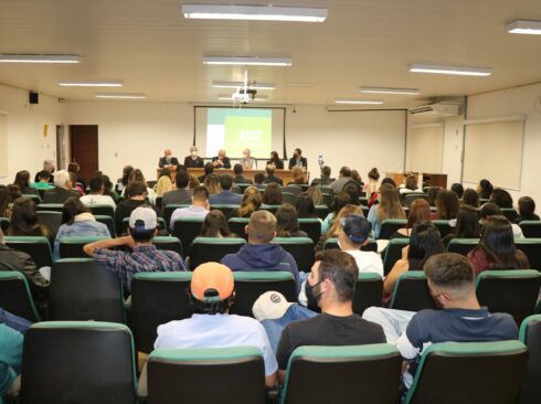 Auditório lotado da Unesp Botucatu tem ao fundo mesa composta por representantes do CRMV-SP e da faculdade de Medicina Veterinária e Zootecnia.