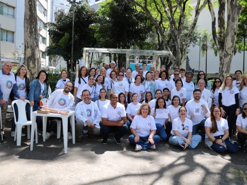 Pessoas usando camiseta branca com logo do FCAFS pousando para foto.