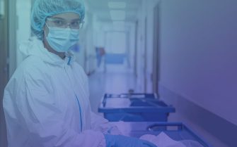 Mulher usando jaleco branco e mascara n95 e óculos de proteção em laboratório.