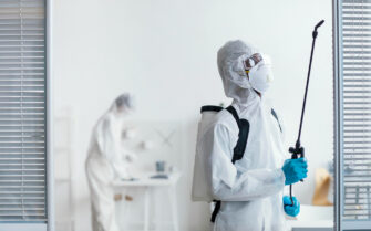 Imagem mostra equipe fazendo limpeza e dedetização. São dois homens, eles usam EPIs como luva, máscara e roupa de proteção.
