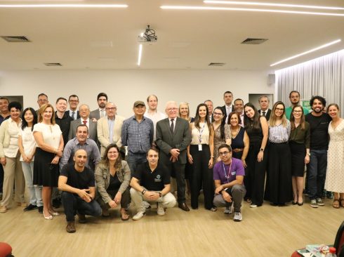 No auditório, participantes, mulheres e homens, lado a lado, posam para a foto ao final do evento.