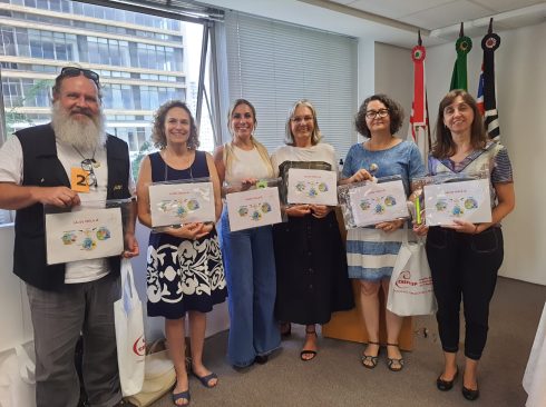 Seis membros do CRMV-SP, Roberto Hoffmann, Adriana Vieira, Cristiane Passos, Suely Stringari, Helia Maria Piedade e Solymar Nunes, posam com cartazes da proposta da criação de política nacional de saúde única que conseguiram aprovar na Conferência Livre de Saúde