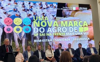 Presidente do CRMV-SP está em um pulpito discursando. Ele é um homem de meia idade, de pele e cabelos claros, veste terno e gravata e usa óculos. Está em frente a um painel do evento 