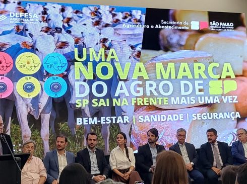 Presidente do CRMV-SP está em um pulpito discursando. Ele é um homem de meia idade, de pele e cabelos claros, veste terno e gravata e usa óculos. Está em frente a um painel do evento 