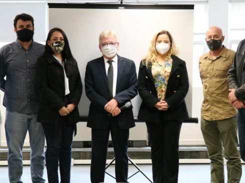 Integrantes da Comissão de Resgate Técnico e o presidente do Conselho estão de pé, posicionados lado a lado, todos de máscara e olhando contentes para a foto