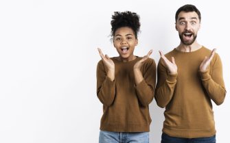 Homem e mulher felizes e com expressão de surpresa.