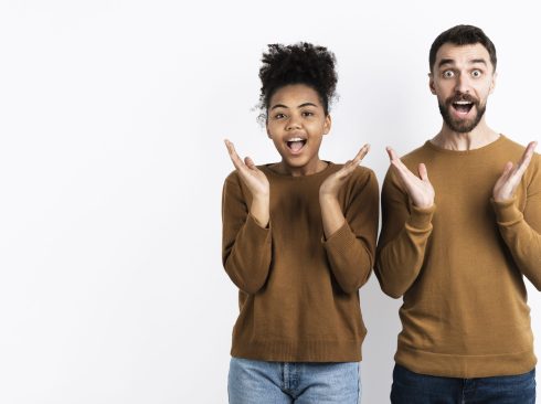 Homem e mulher felizes e com expressão de surpresa.