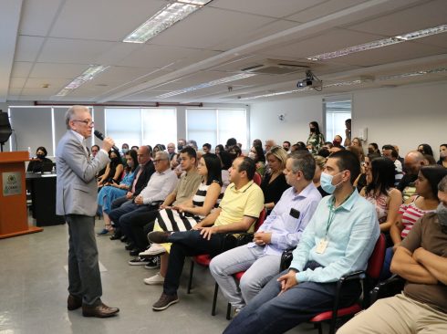 Presidente do CRMV-SP está posicionado de pé a frente de um auditório lotado com colaboradores sentados prestando atenção na apresentação dos resultados 2022.