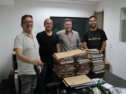 Membros da Comissão de Tomada de Contas do CRMV_SP posam para foto com as pilhas de processos em papel