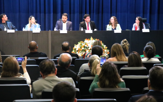 No auditório da Alesp, três homens e três mulheres sentados à mesa, no palco, em frente à plateia de médicos-veterinários.