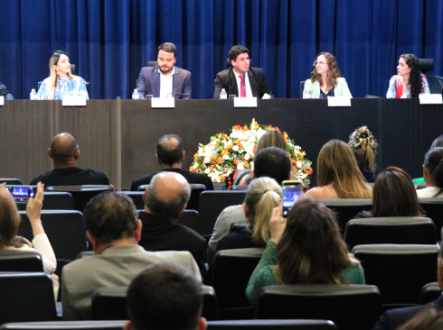 No auditório da Alesp, três homens e três mulheres sentados à mesa, no palco, em frente à plateia de médicos-veterinários.