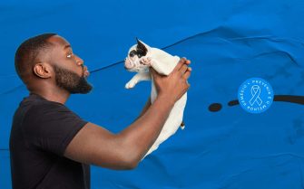 imagem de um homem negro, segurando um gato branco.